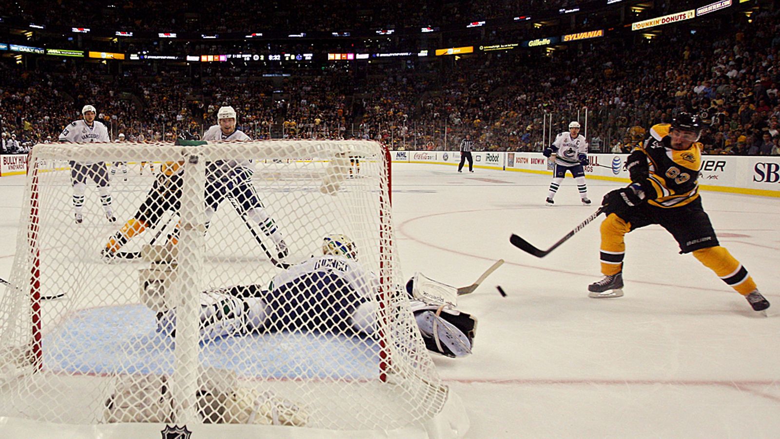 Brad Marchand maalaa, kun maalivahti Roberto Luongo makaa jäässä.