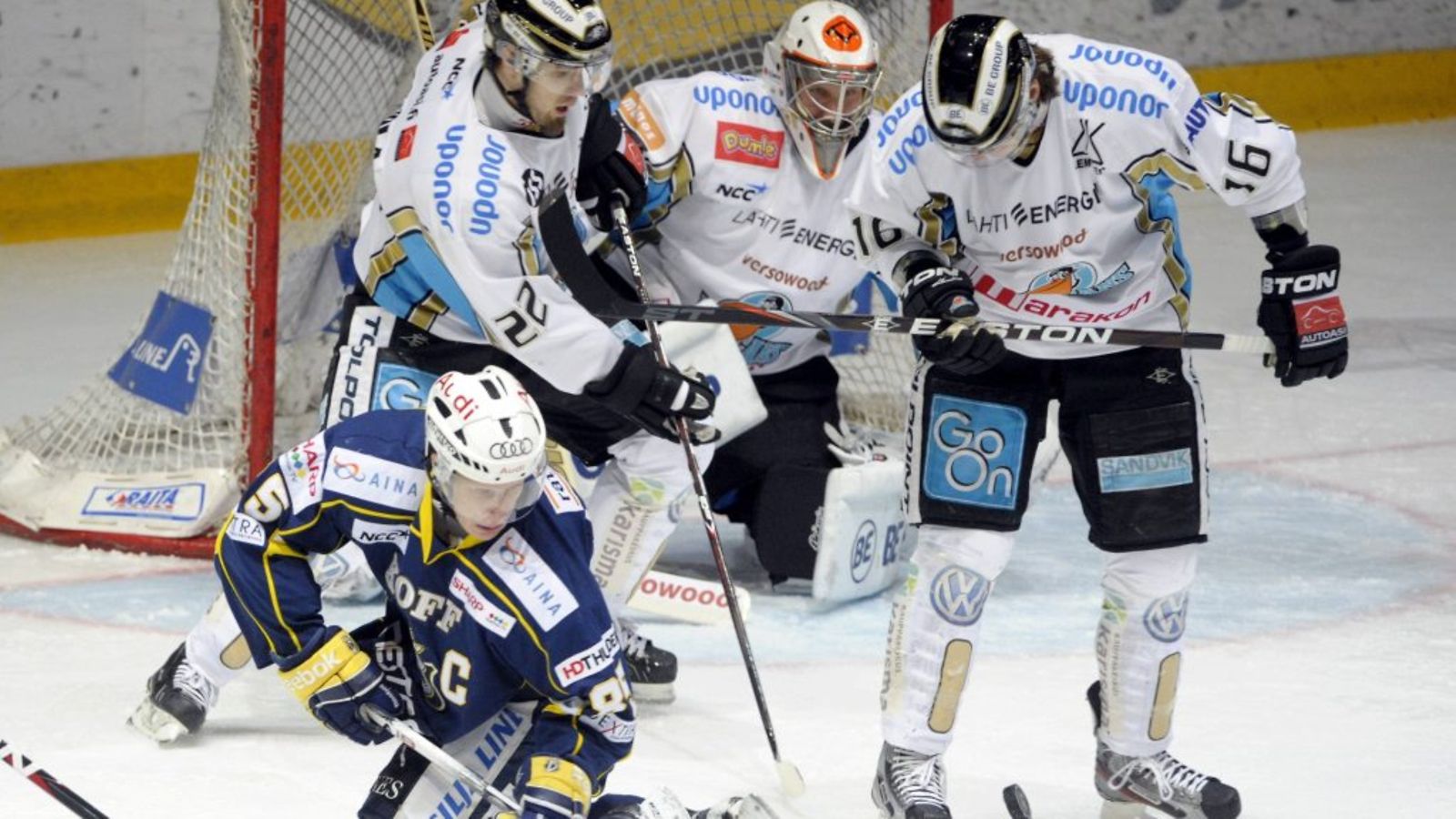 Bluesin Toni Kähkönen polvillaan Pelicans-pelaajien Markus Seikolan, maalivahti Niko Hovisen ja Justin Hodgmanin edessä. Kuva: Lehtikuva