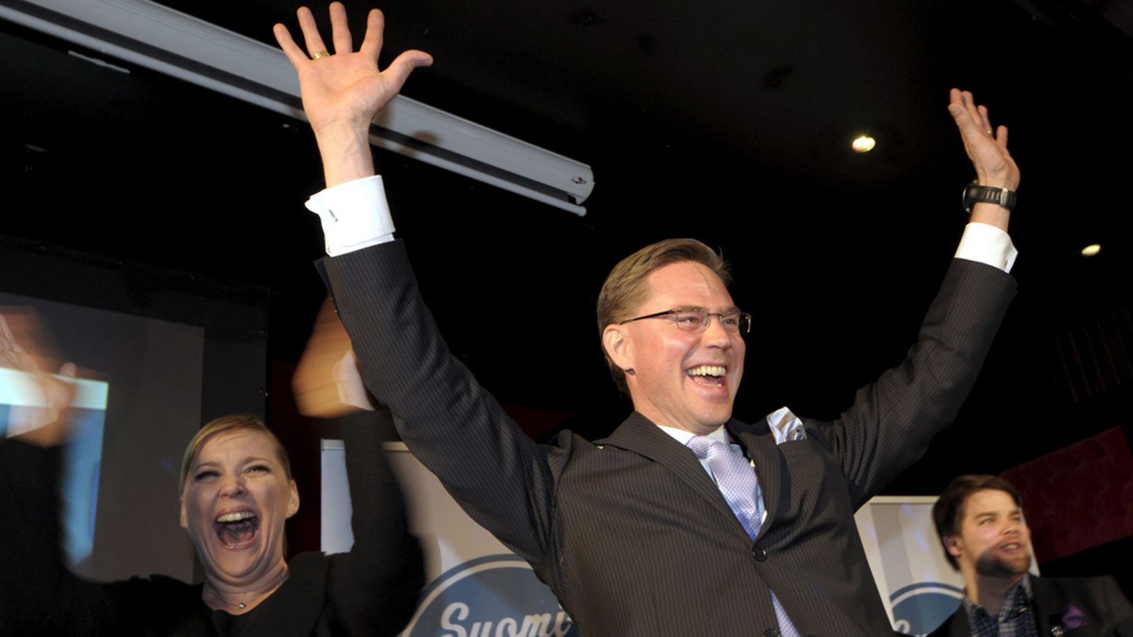Kokoomuksen puheenjohtaja Jyrki Katainen (oik.) ja puoluesihteeri Taru Tujunen kuuntelevat ennakkoäänten tulosta vaalivalvojaisissa
