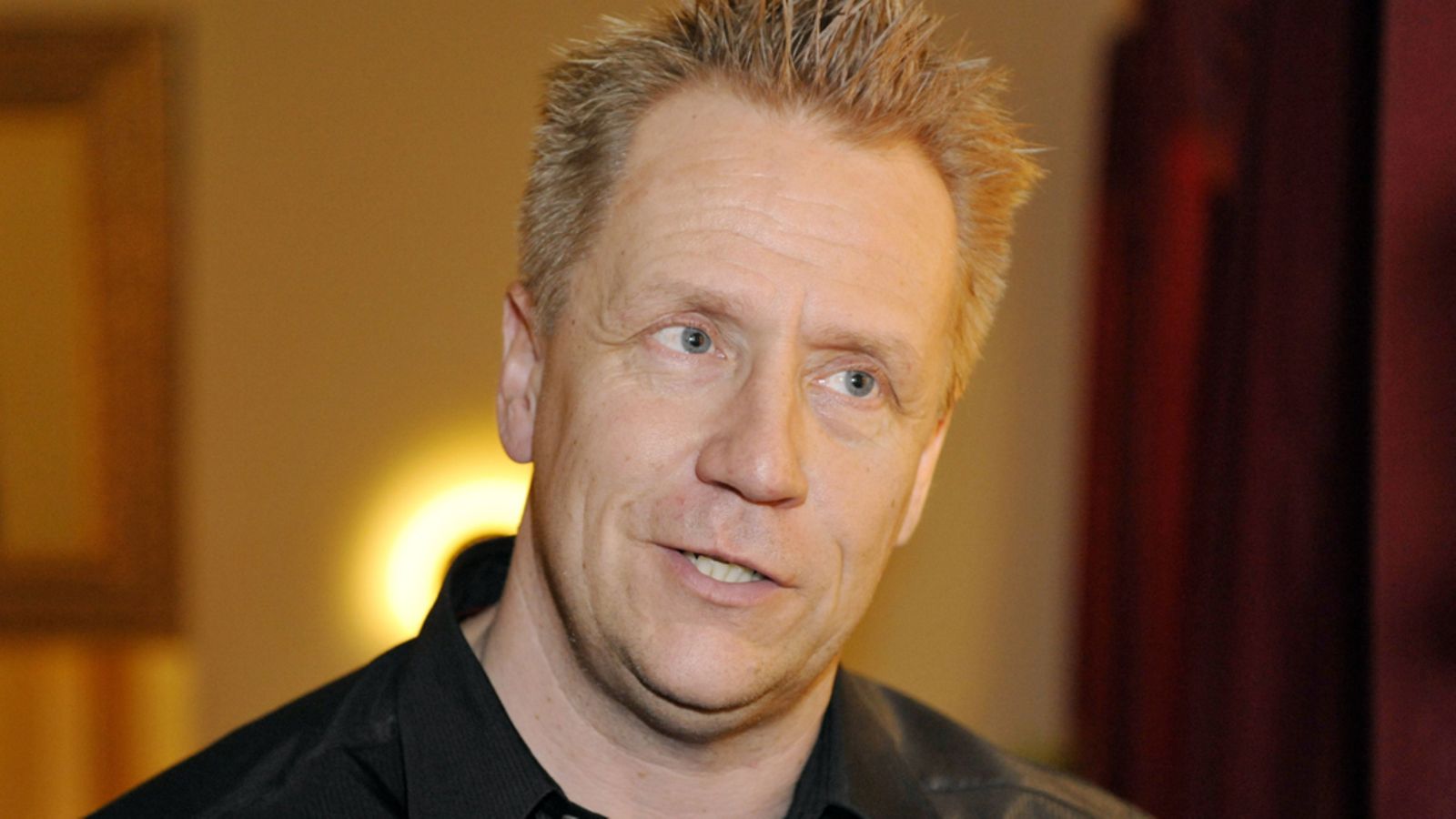 Olli Lindholm käyttää kuulolaitetta.