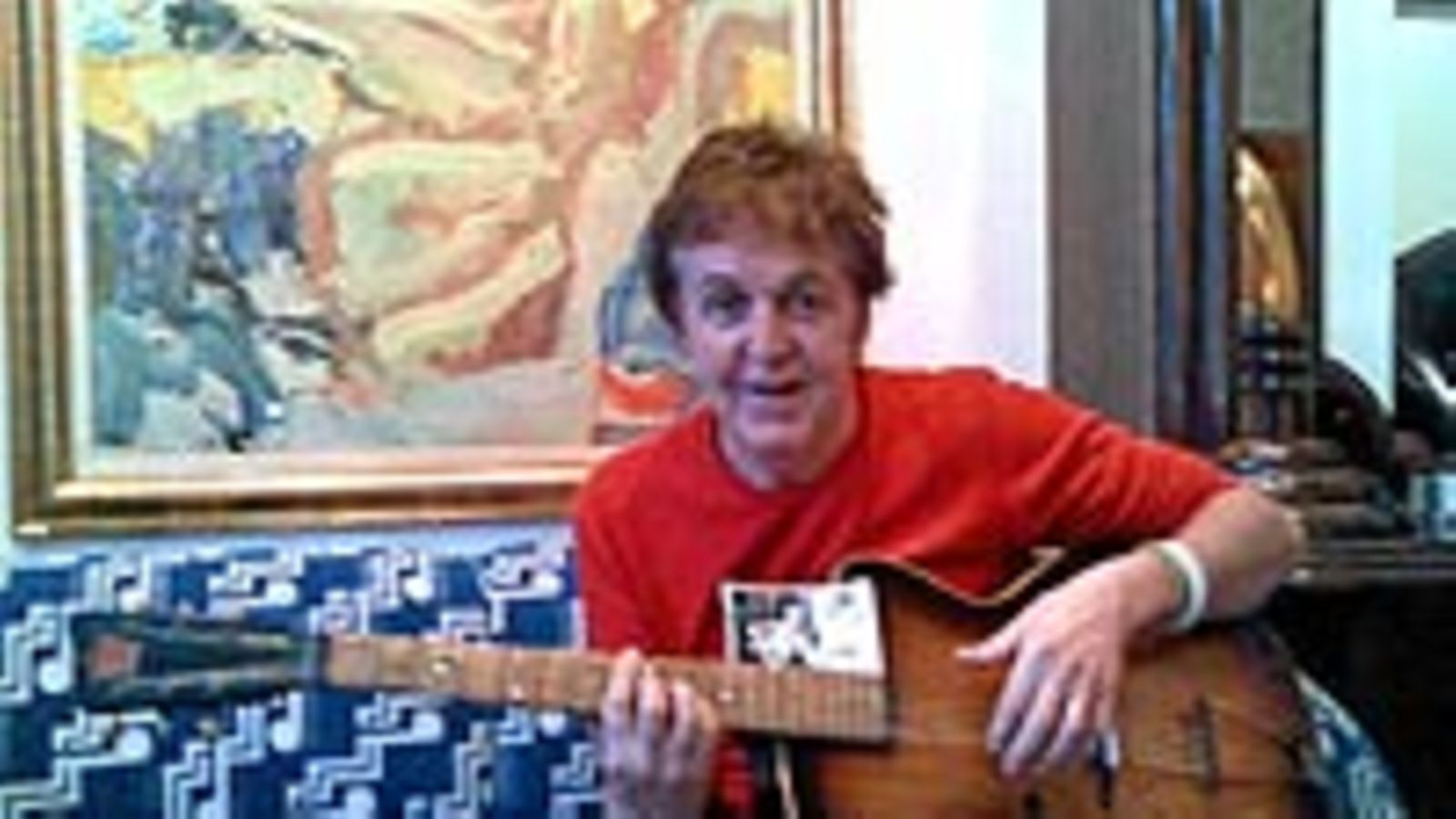Paul McCartney soittaa ensimmäistä kitaraansa (Photo by Getty images)