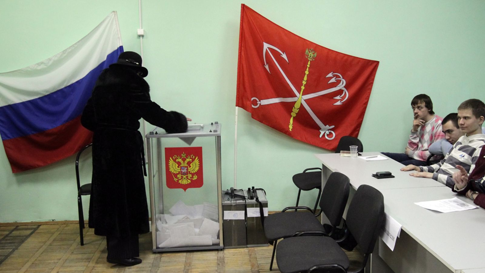 Elections observers watch a woman casting her ballot a polling station in St.Petersburg, Russia 04 March 2012, during presidential elections. Russia elects its president among five candidates, Mikhail Prokhorov, Russian Prime Minister Vladimir Putin, Communist party leader Gennady Zyuganov, Liberal Democratic Party of Russia (LDPR) leader Vladimir Zhirinovsky and Just Russia political party leader Sergey Mironov. EPA/ANATOLY MALTSEV
