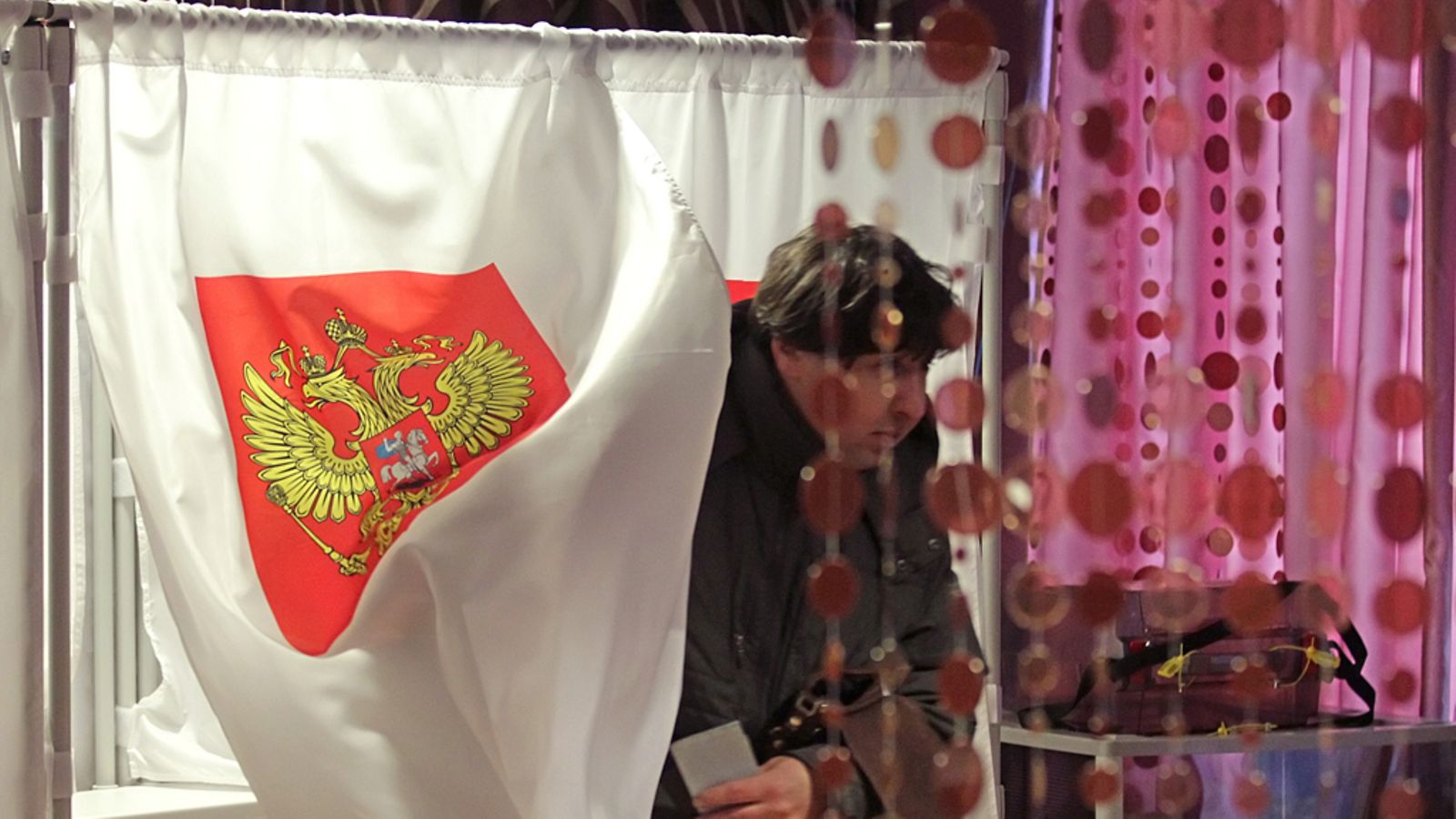A man leaves a voting booth to cast his ballot at a polling station in town of Podolsk, some 20 km south of Moscow, Russia, 04 March 2012. Russia elects its president among five candidates, Mikhail Prokhorov, Russian Prime Minister Vladimir Putin, Communist party leader Gennady Zyuganov, Liberal Democratic Party of Russia (LDPR) leader Vladimir Zhirinovsky and Just Russia political party leader Sergey Mironov. EPA/MAXIM SHIPENKOV