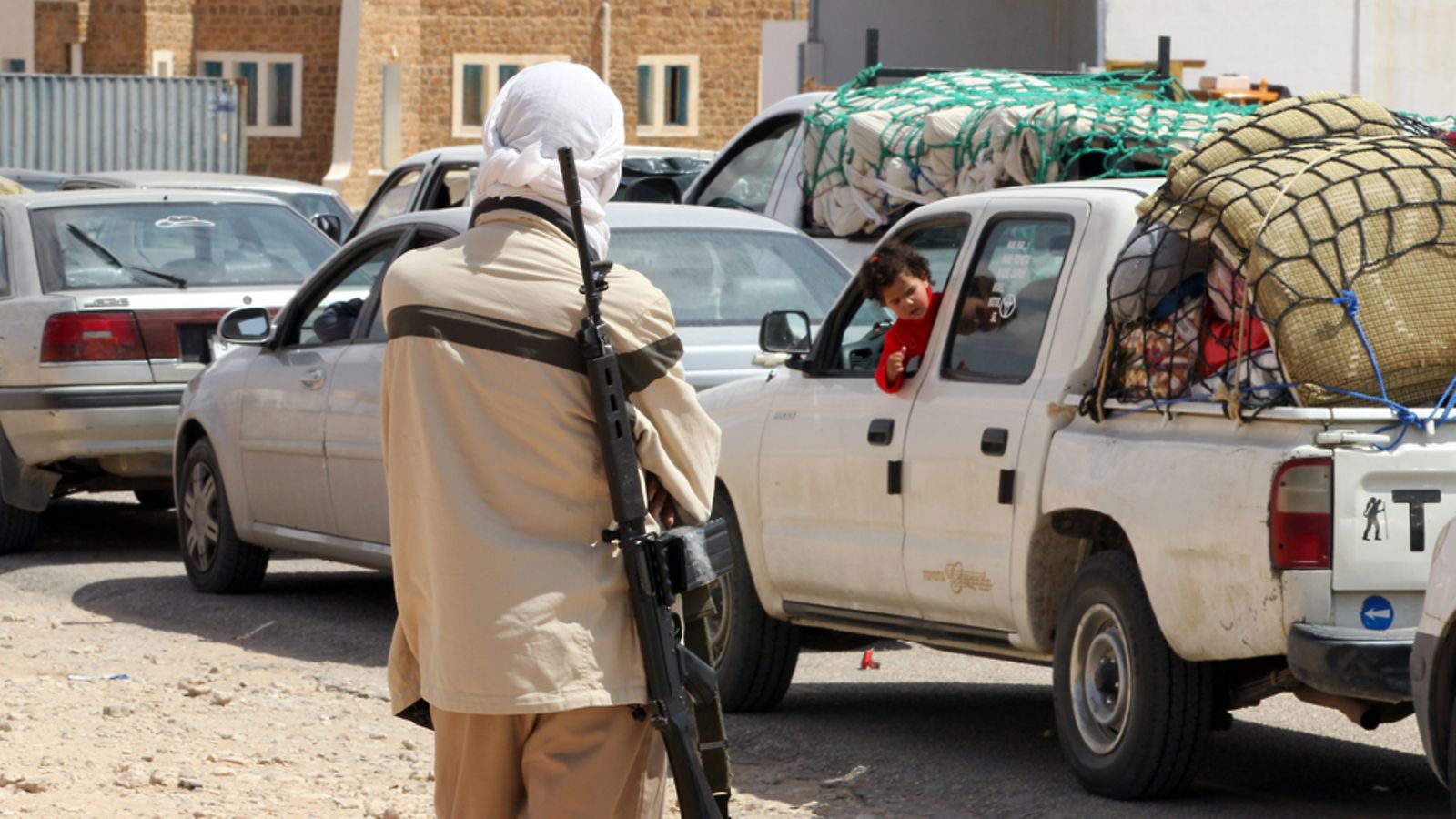 Gaddafin joukoissa oelva taistelija vahtii rajanylittäjiä Tunisian ja Libyan rajalla.