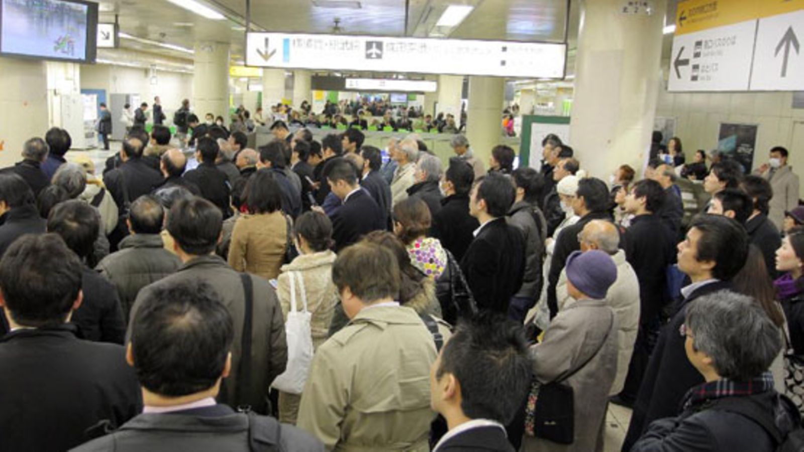 Japanilaiset seuraavat uutisia juna-asemalla. Junat eivät kulje maanjäristyksen jälkeen. Kuva: Getty Images/All Over Press