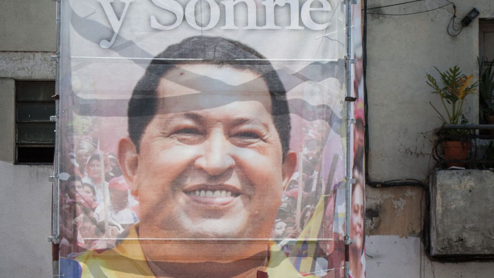 A man in a motorcycle waits in front of a billboard showing Venezuelan President Hugo Chavez, outside the Military Hospital in Caracas, Venezuela, 01 March 2013.