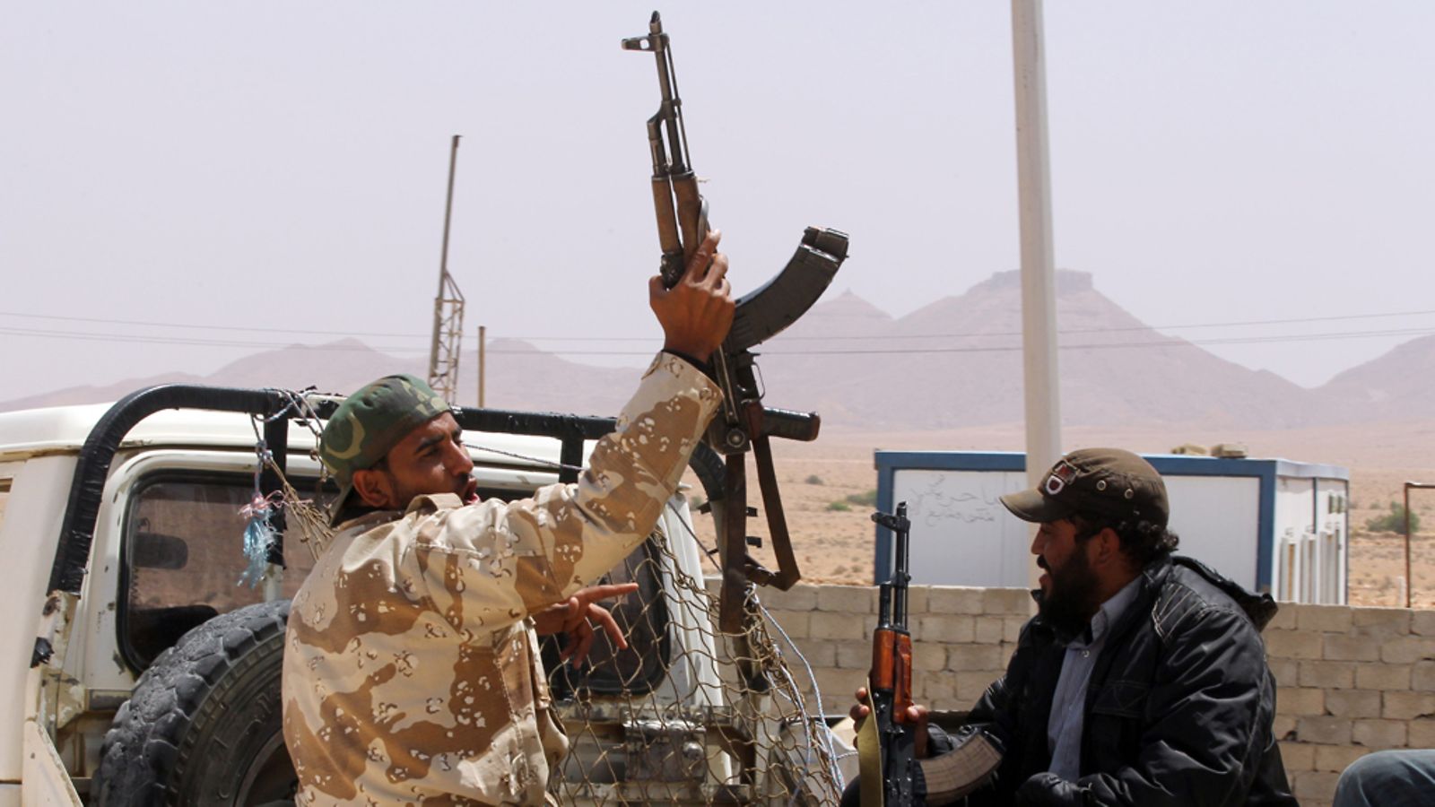 Libyalainen kapinallinen nostaa asettaan Wazinin raja-alueella 9.5.2011. Kuva: EPA