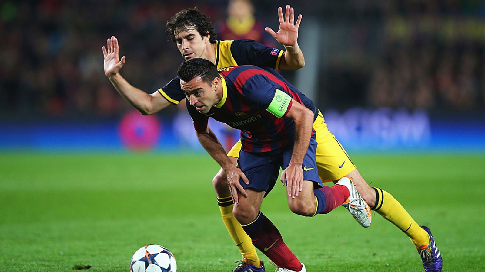 Xavi (edessä) ja Tiago taistelevat pallosta.
