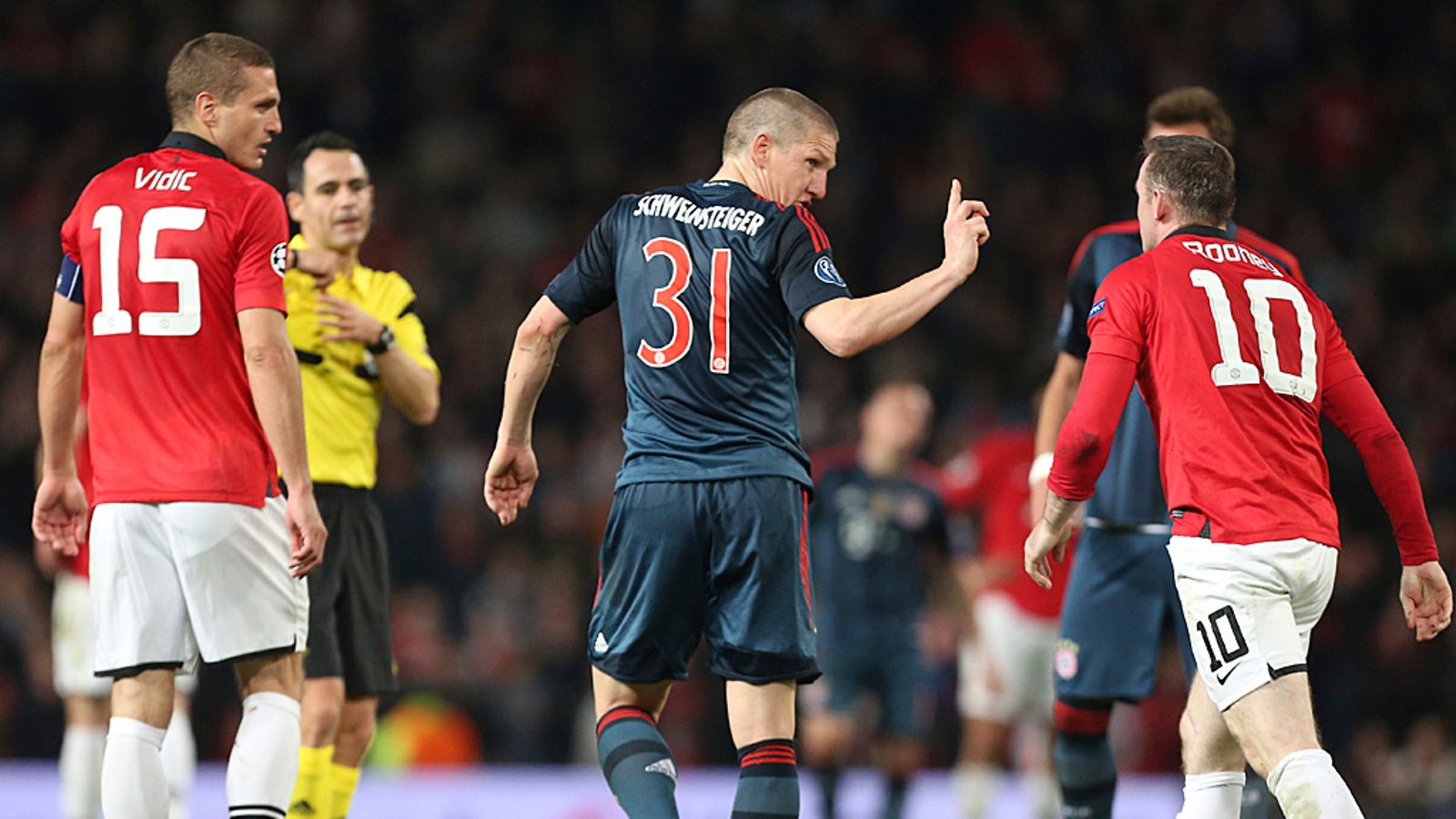 Bastian Schweinsteiger toruu Wayne Rooneya ulosajonsa jälkeen.