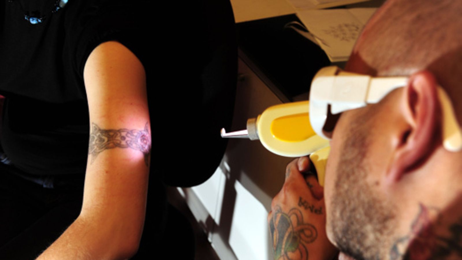 Anton Holmberg poistamassa Jeanette Pitkäsen tatuointia Legacy Tattoo -liikkeessä Helsingissä, 29. syyskuuta 2009.