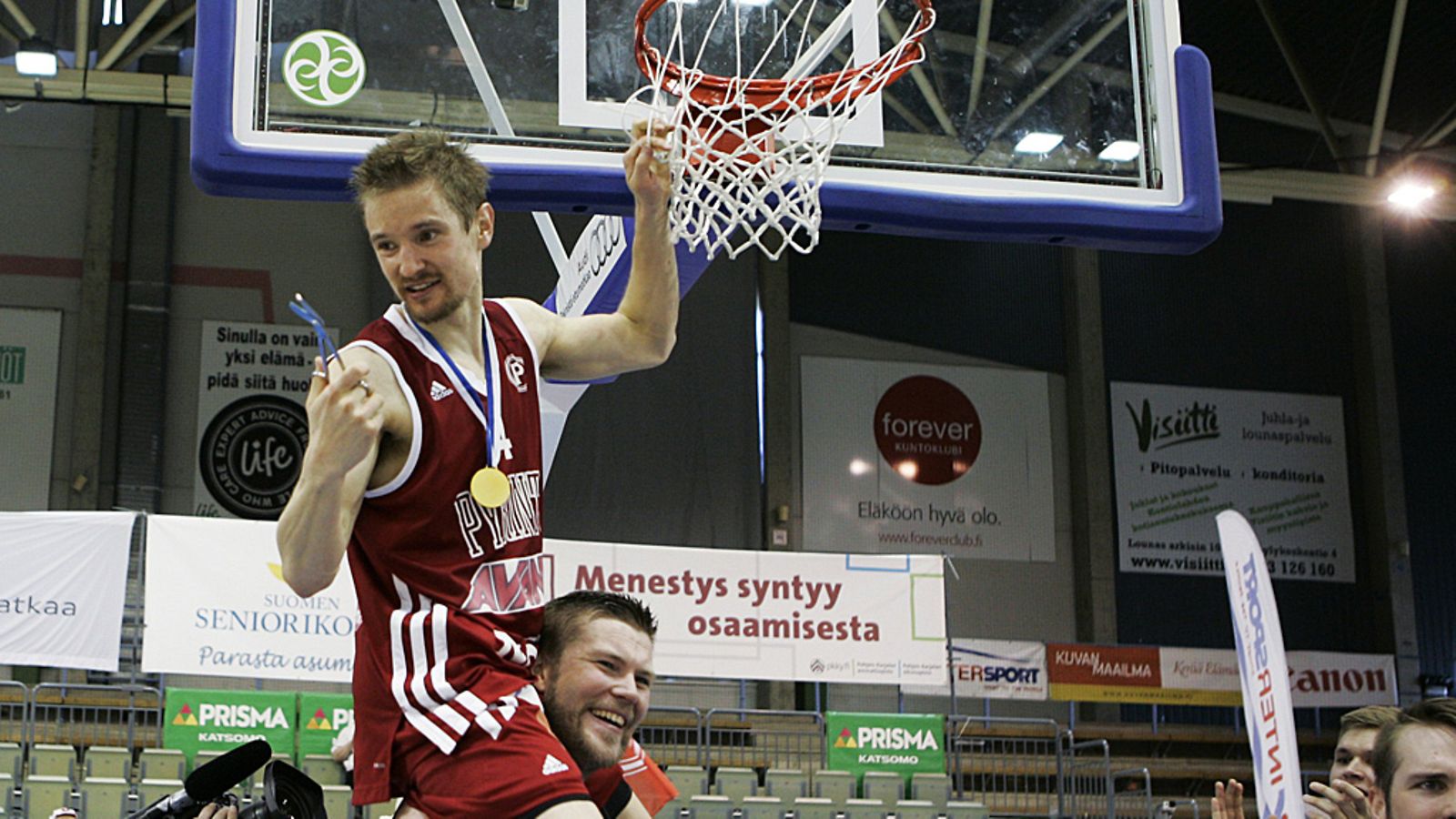 Antero Lehto leikkaa korisukan mestaruuden kunniaksi.
