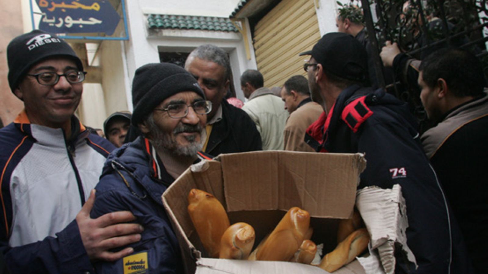 Tunisialaismiehet kantavat kotiin leipää jonottamisen jälkeen pääkaupunki Tunisissa. Maasta paennut presidentti yritti lieventää mellakoita muun muassa laskemalla leivän hintaa viime viikolla. Kuva: EPA