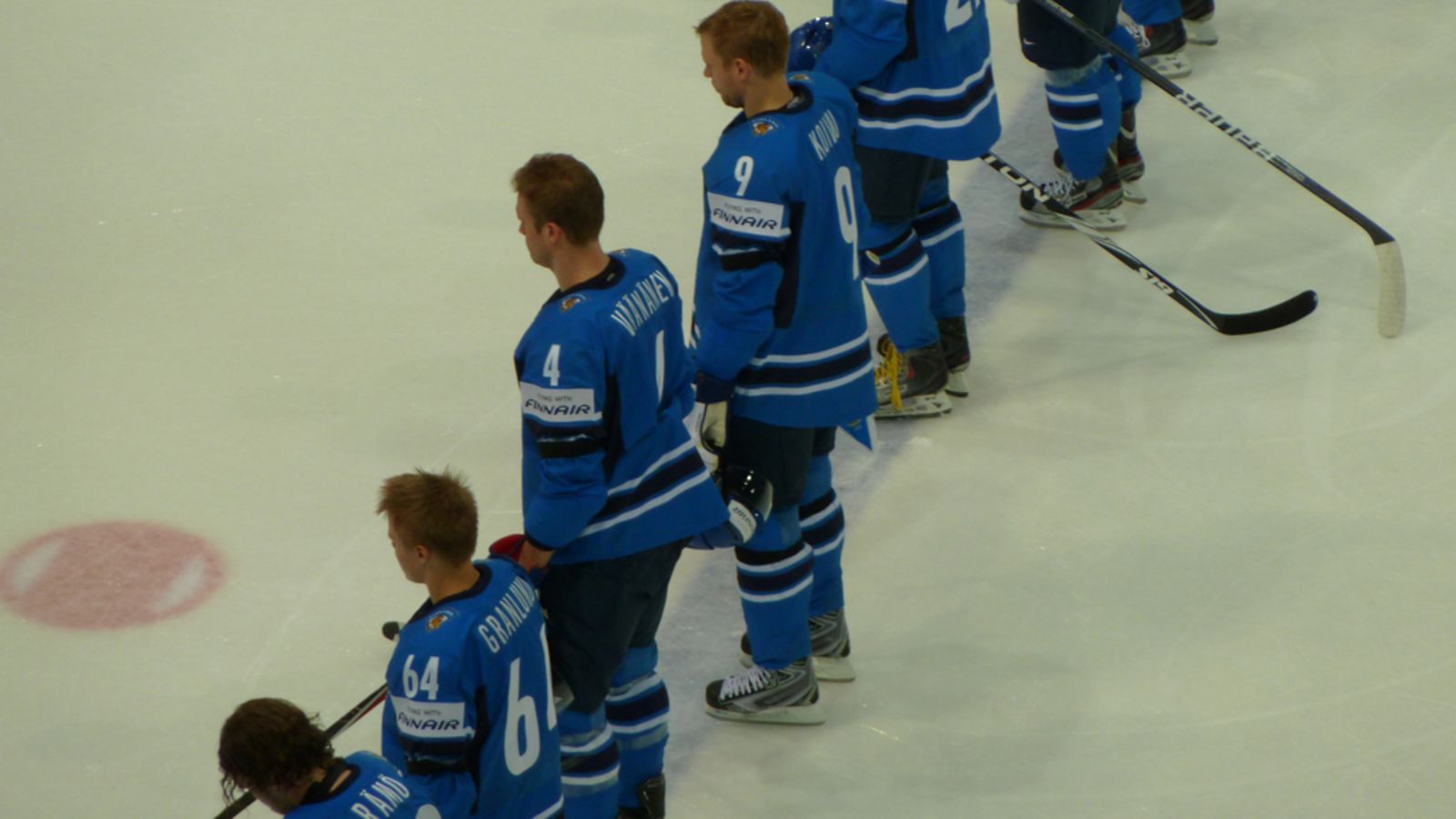 Suomen pelaajat pelaavat Ranska-Suomi-jääkiekko-ottelussa musta surunauha kädessään. Surunauhalla kunnioitetaan Leijona-legenda Pekka Marjamäen muistoa.