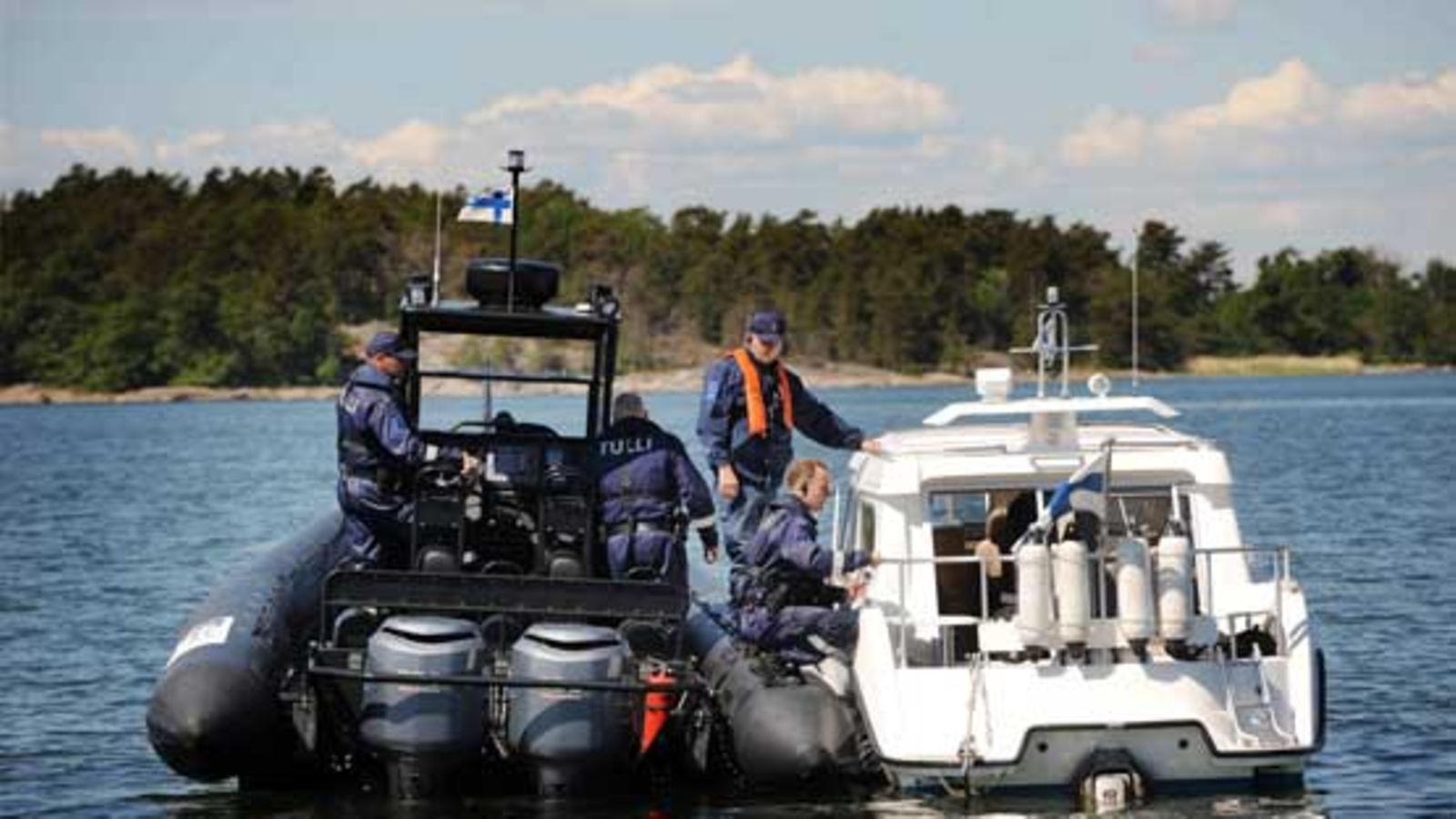 Tullitarkastajat tarkastavat ohikulkevan veneen Tullin uuden koekäytössä olevan RIB-venekaluston esittelyssä Porkkalassa 23. kesäkuuta 2009. Kuva: Lehtikuva.
