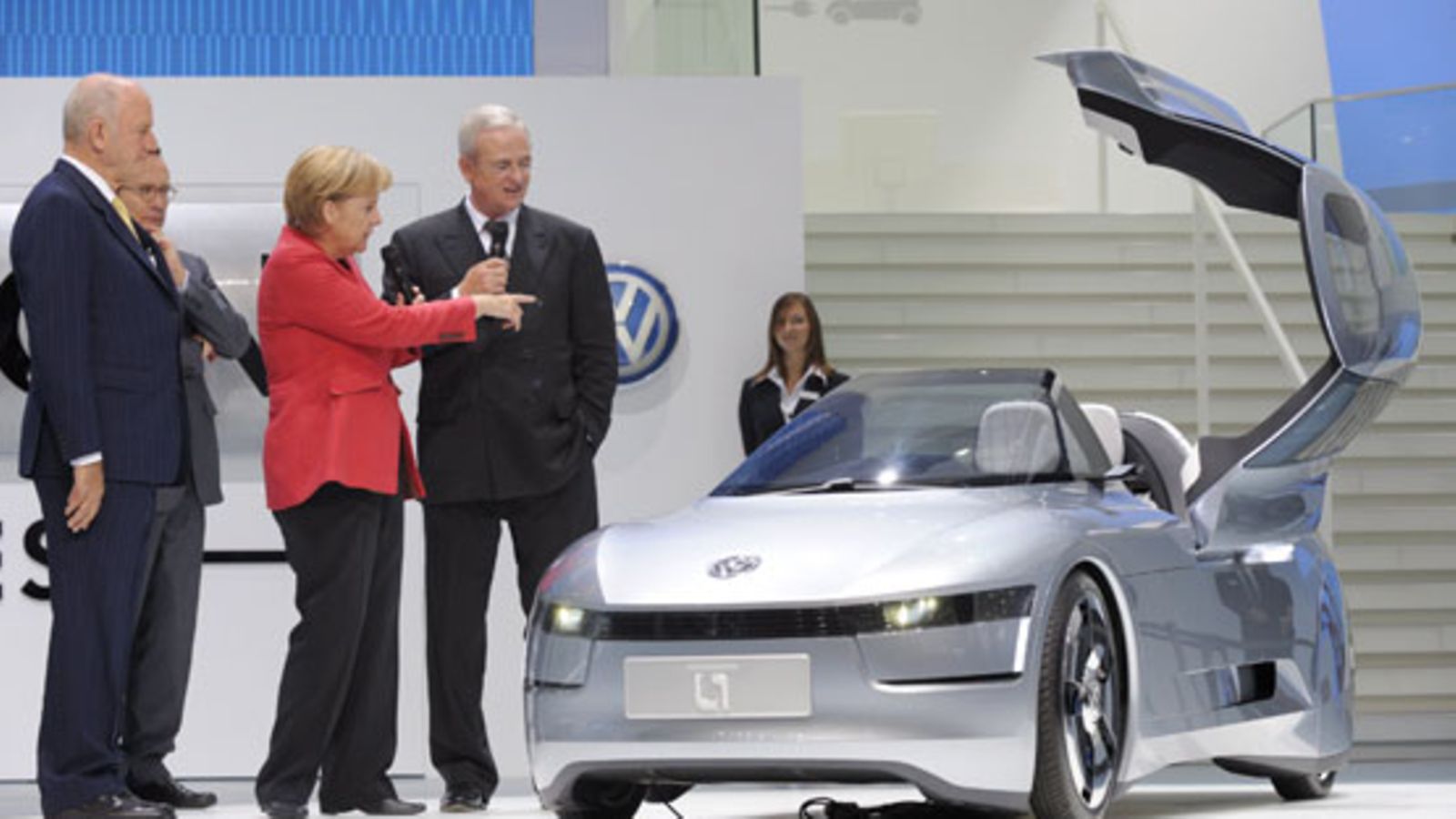 Saksan liittokansleri Angela Merkel ihmettelee artikkelin auton edeltäjää, volkswagen L1:stä, Saksan autonäyttelyssä 2009. Kuva: EPA