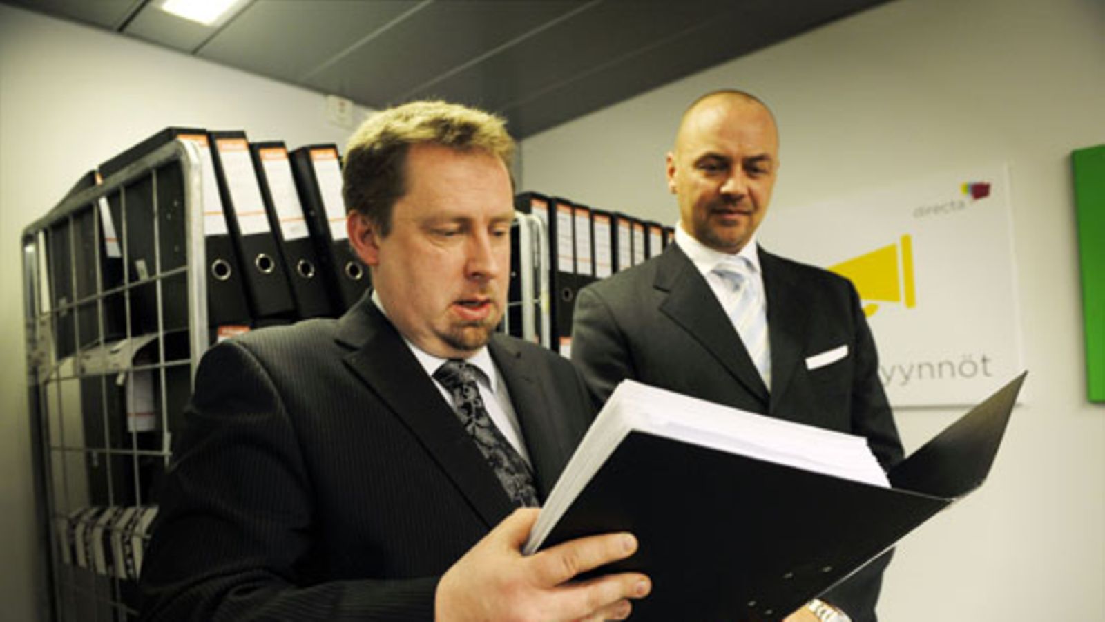 Directan viestintäjohtaja Jussi Lähde (vas.) ja toimitusjohtaja Fredrik Schauman yrityksen tiedotustilaisuudessa Helsingissä 31. maaliskuuta 2010. Petostutkinnan kohteena olevan Directan info koski syyttäjälle annettavaa vastinetta. Directan loppulausunto liitteineen (taustalla) käsittää yhteensä 50 000 sivua, painoltaan 240 kiloa.KUVA: LEHTIKUVA