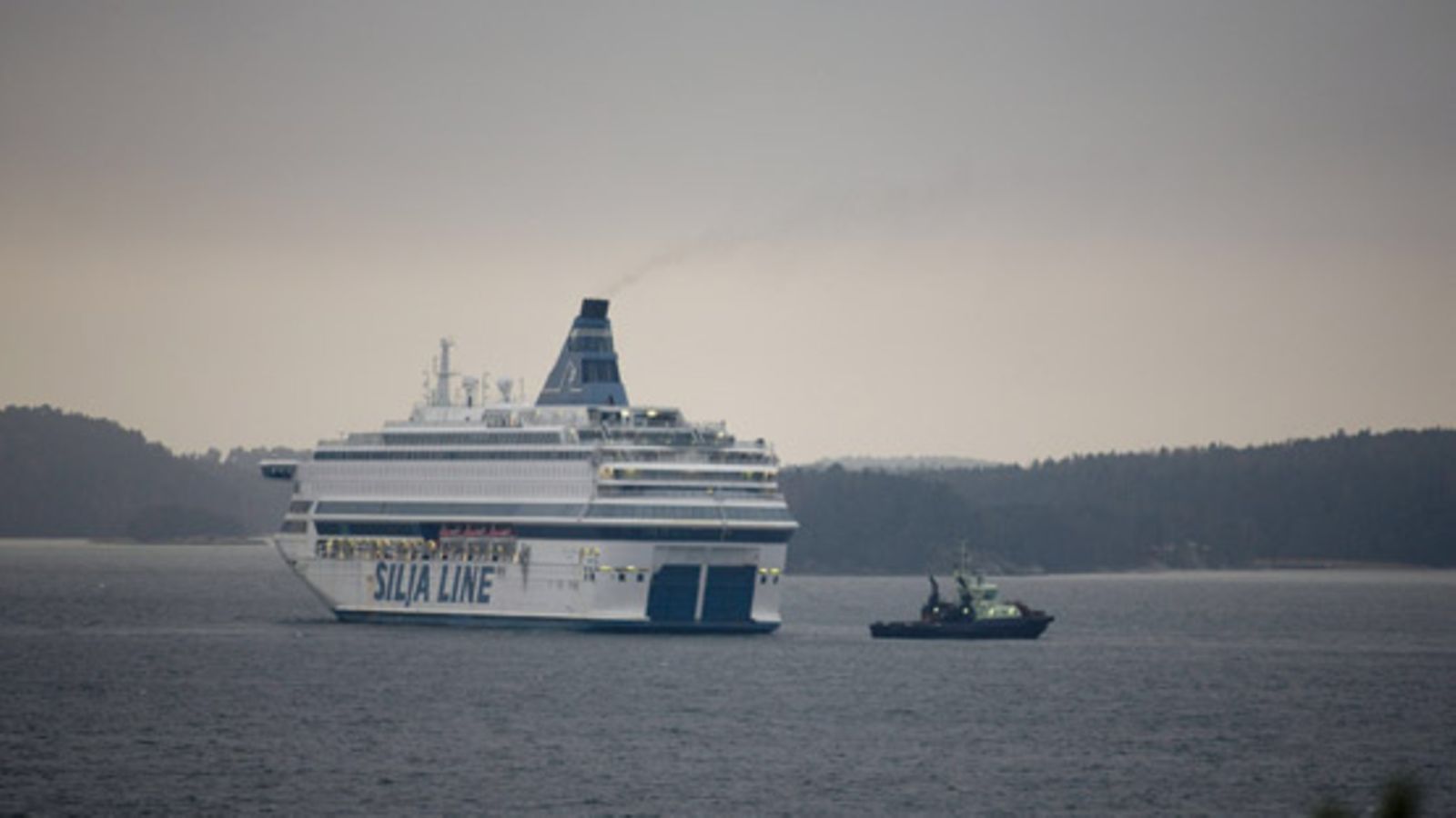 Silja Europa hinaajan saattelemana satamaan marraskuussa 2009. Lehtikuva