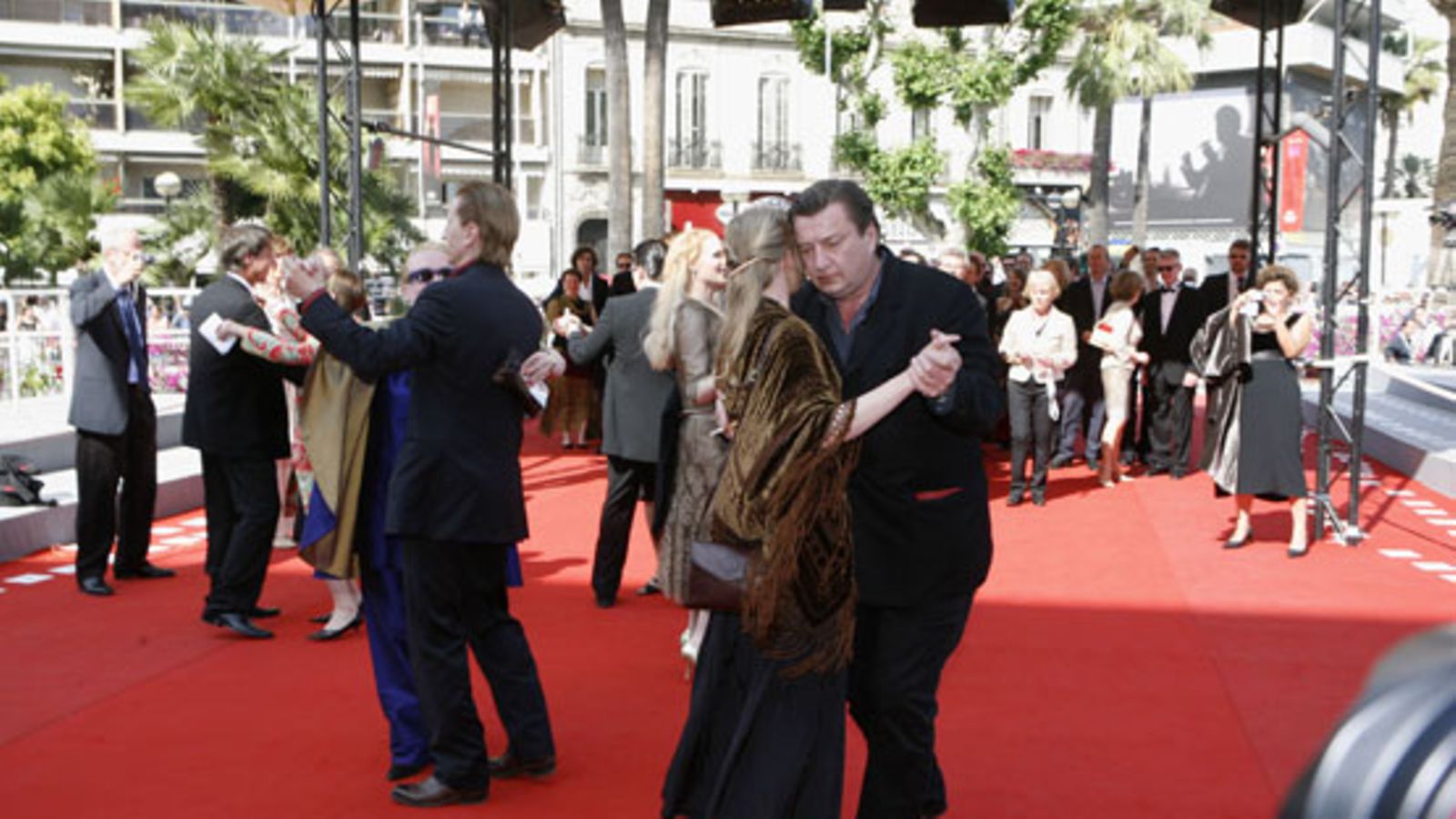 Ohjaaja Aki Kaurismäki (edessä) tanssii tangoa Paula-vaimonsa kanssa punaisella matolla Cannesin elokuvajuhlilla 22. toukokuuta 2006. Kuva: Lehtikuva