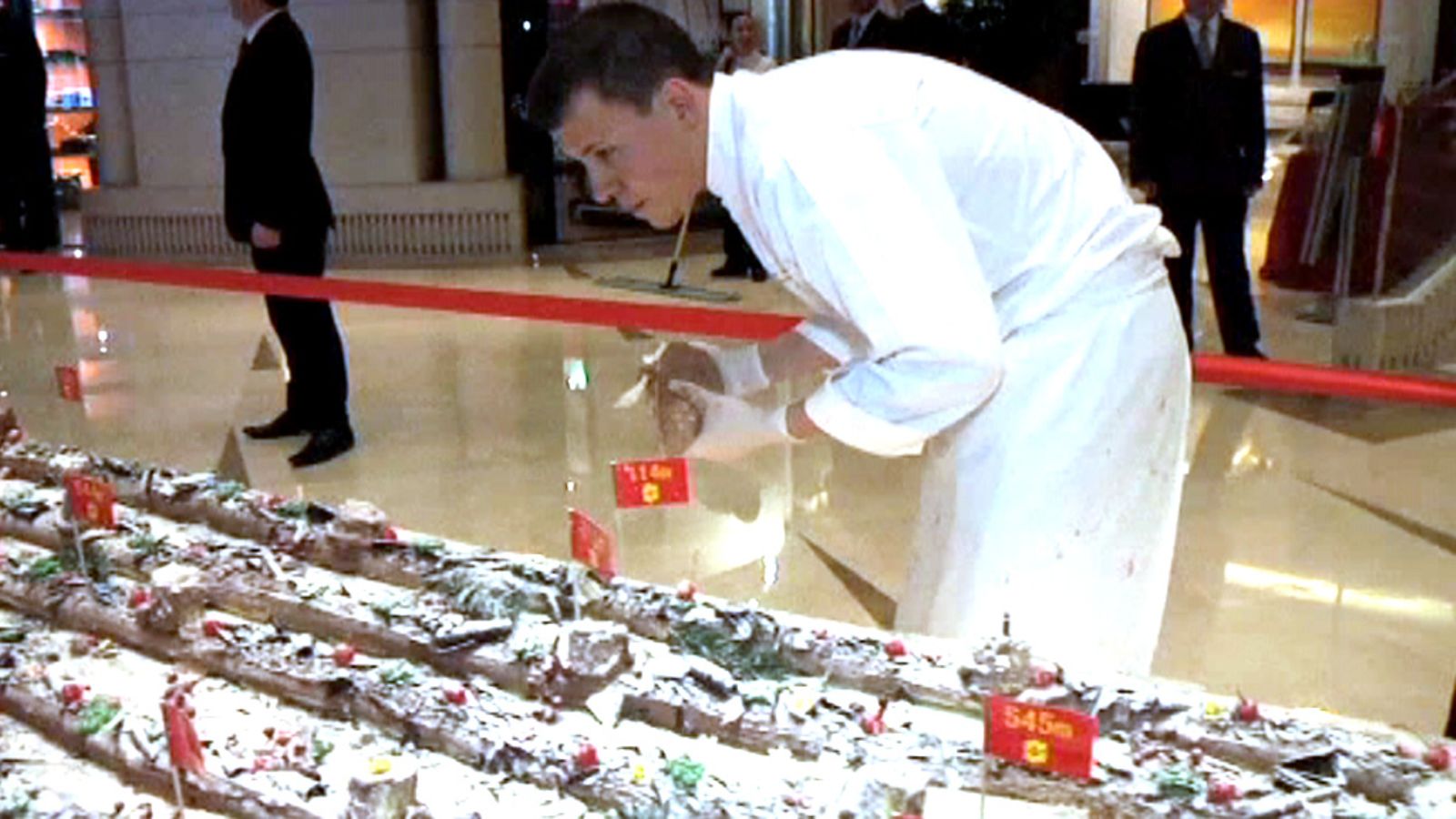 Shanghaissa leivottu yli kilometrin pituinen kakku on päässyt Guinnessin ennätysten kirjaan. Kuva AP:n videomateriaalista.