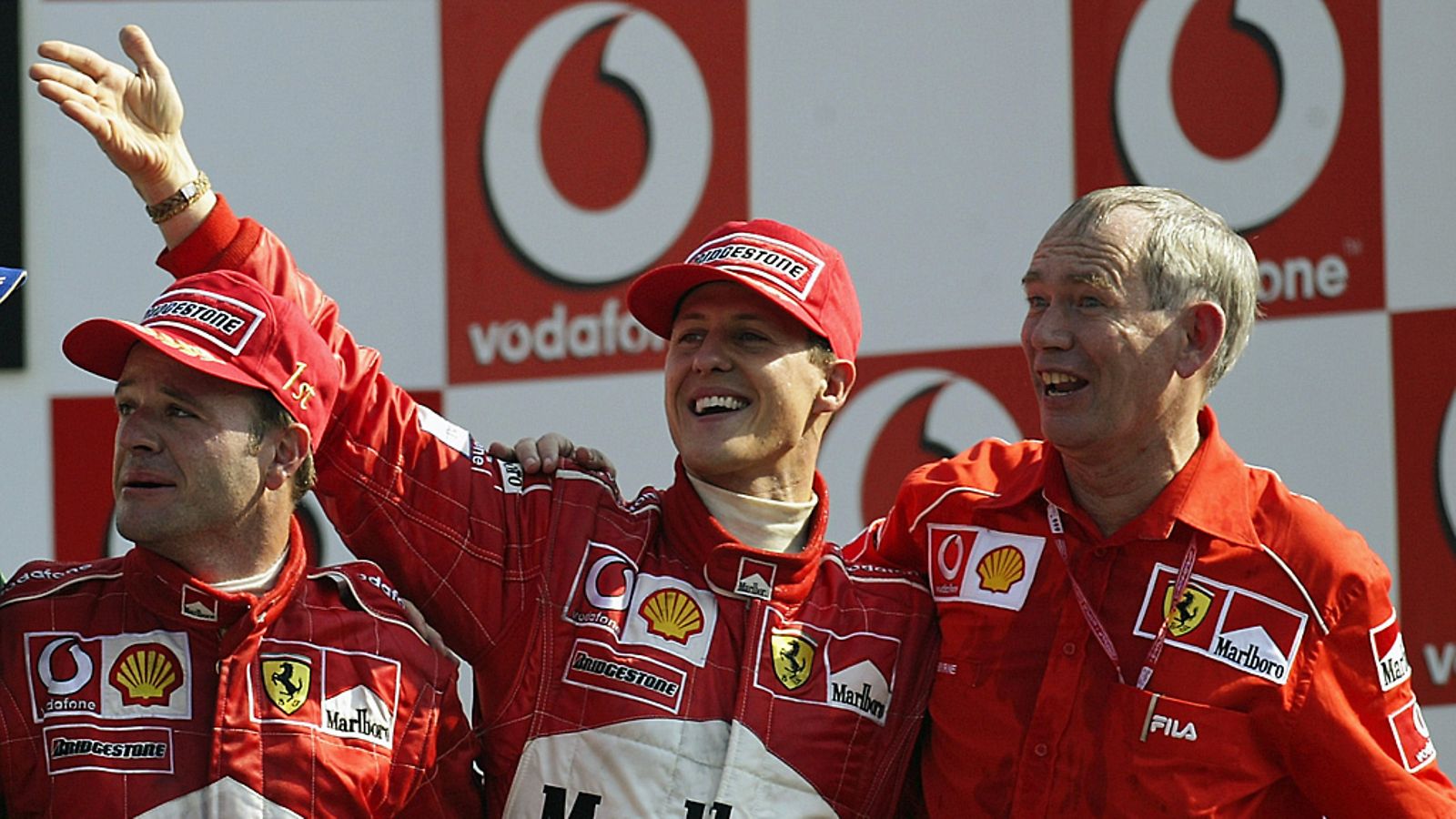 Rory Byrne (oik.) Rubens Barrichellon ja Michael Schumacherin kanssa palkintopallilla vuonna 2002.