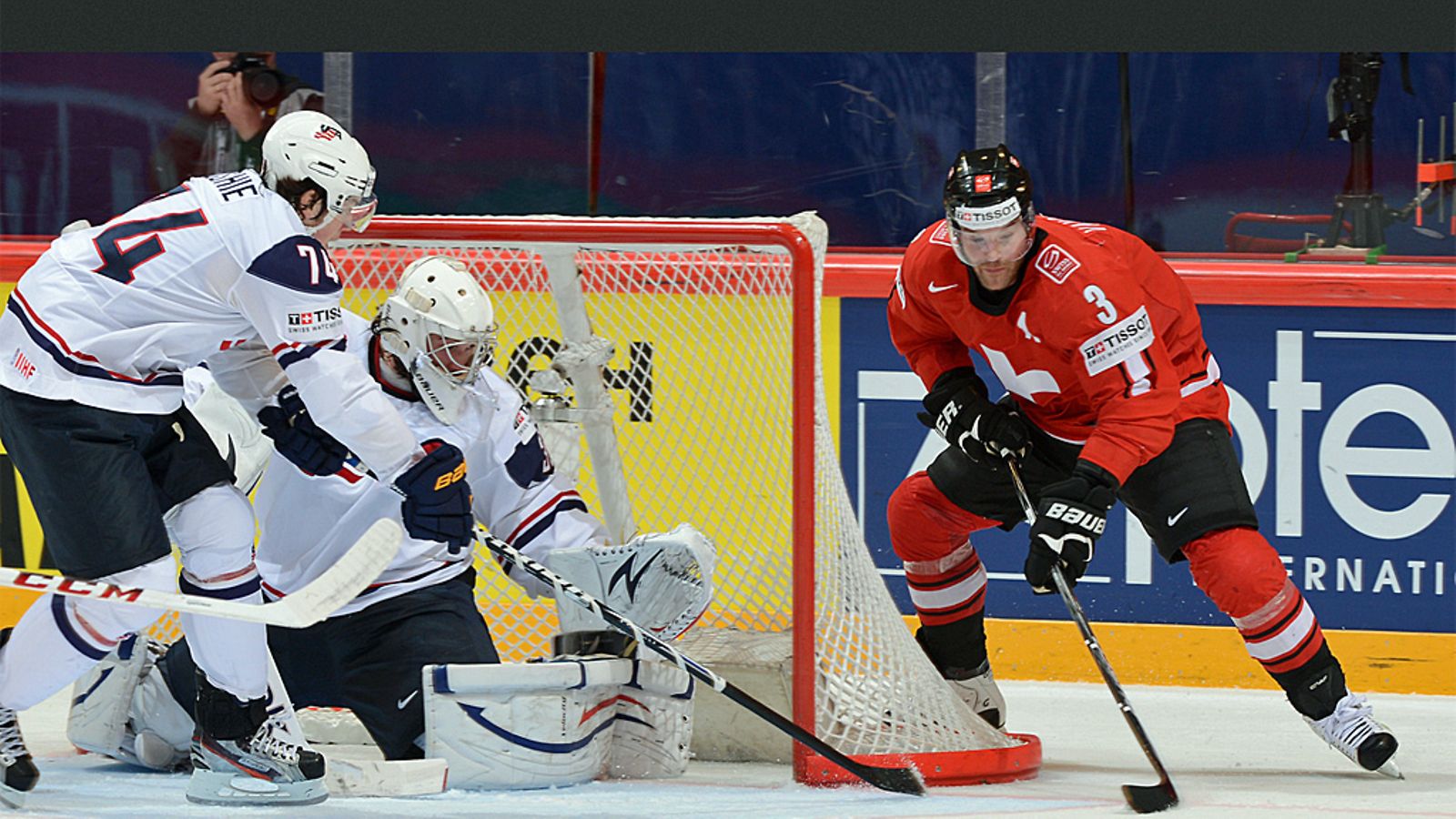 Julien Vauclair ahdistelee USA:n maalivahtia John Gibsonia. TJ Oshie puolustaa.
