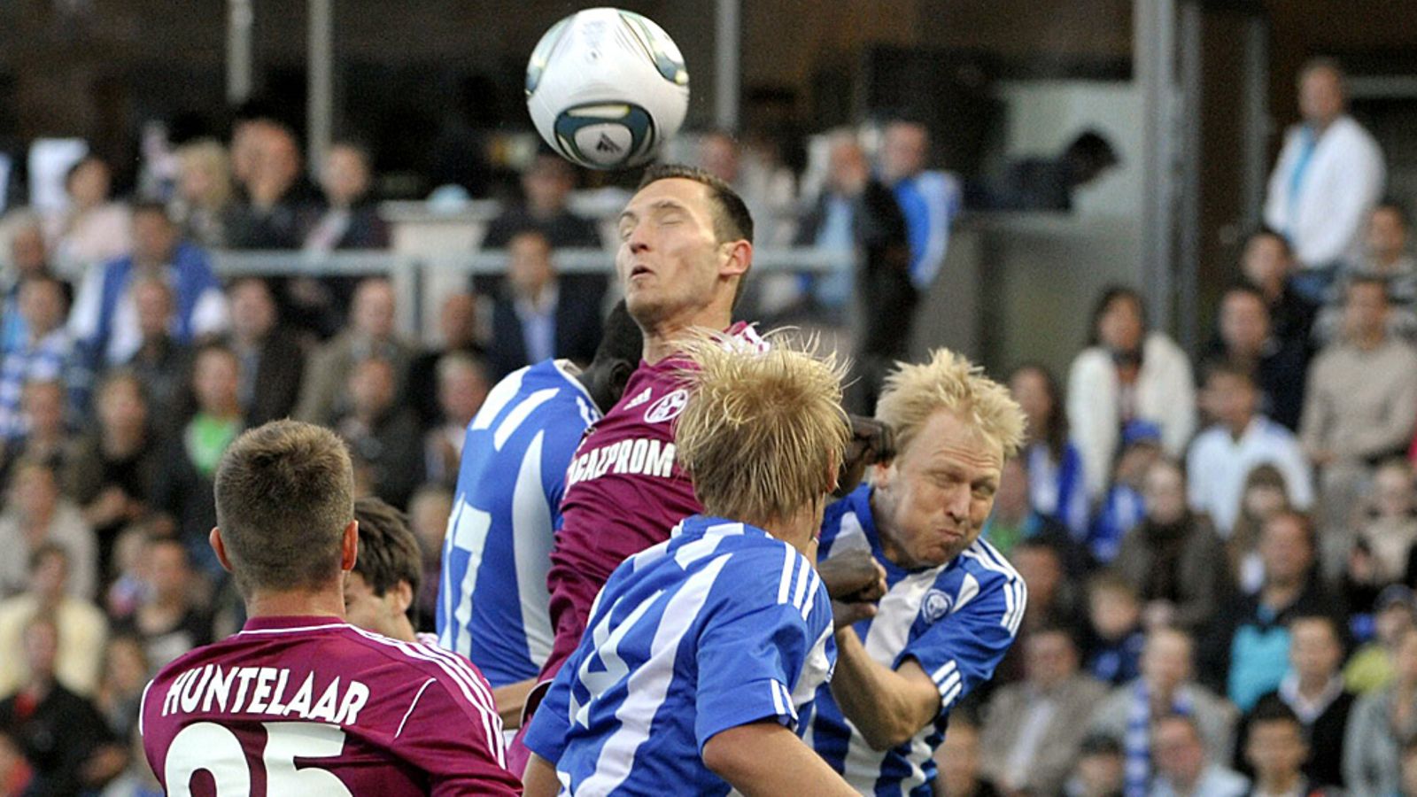 Schalken Benedikt Höwedes HJK-pelaajien puristuksessa.