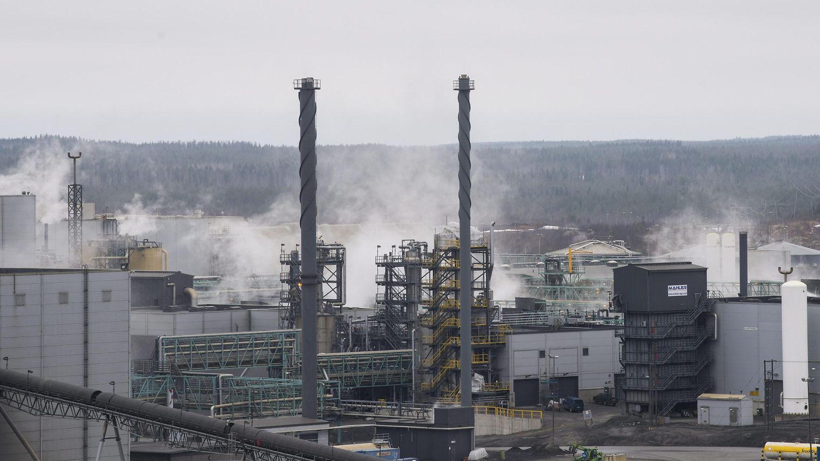 Terrafamen tehdas höyryää keskellä metsämaisemaa.