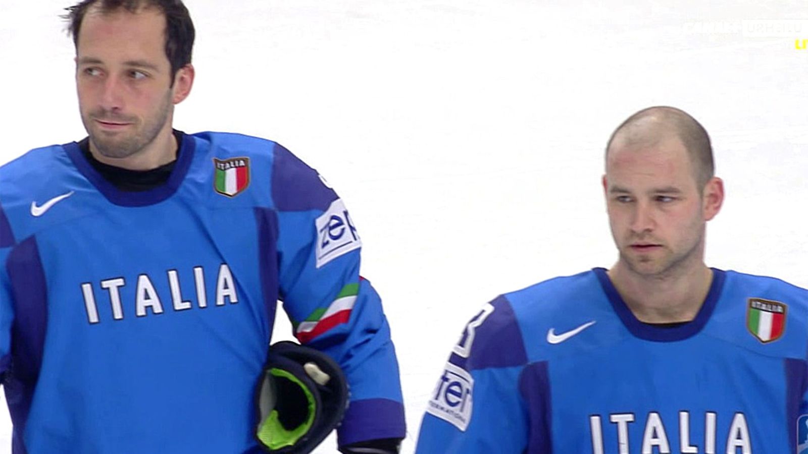 Italian pelaajat seuraavat mieslaulajan esitystä.