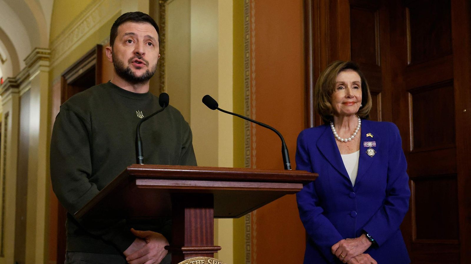 Presidentti Zelenskyi puhuu valkoisessa talossa, taustalla Nancy Pelosi.