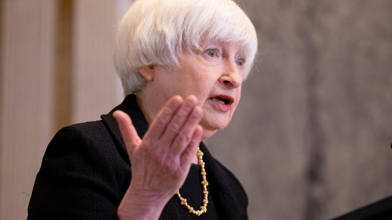 Janet Yellen puhuu käsi ojossa vakavan näköisenä.