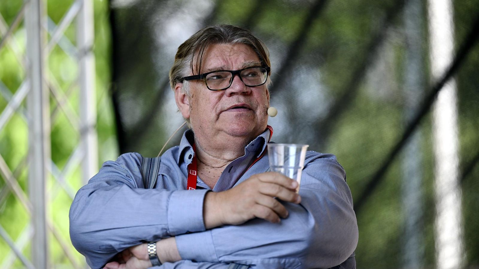 Soini istuu muovinen juomalasi kädessään SuomiAreenan lavalla.