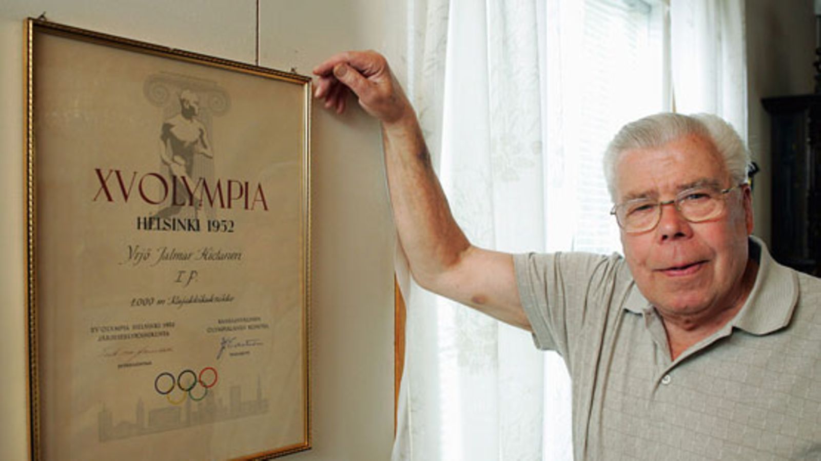 Yrjö Virtanen esittelee Helsingin olympialaisten kunniakirjaa vuonna 2004.