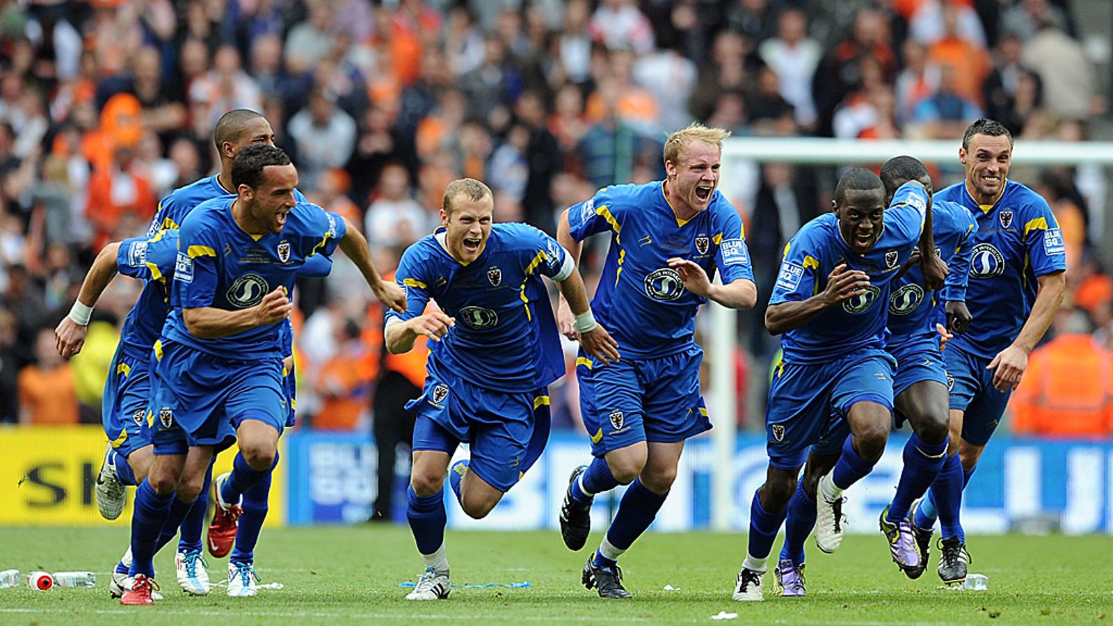 AFC Wimbledon -pelaajat juhlivat ratkaisevan rangaistuspotkun onnistuttua.