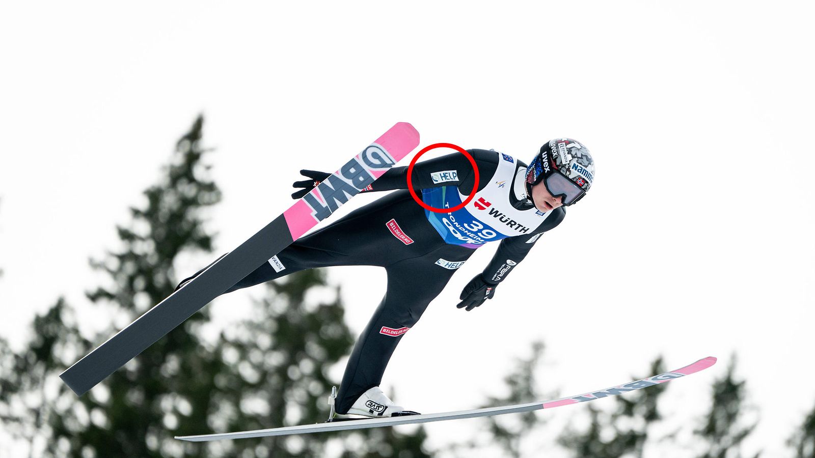 Marius Lindvik Trondheimin MM-kisoissa. Hyppypuvusta ympyröity mainos poistuu nyt kohuun joutuneen maajoukkueen välineistä.