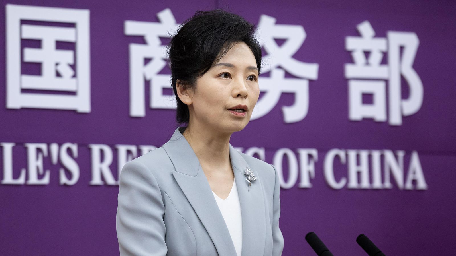 Kiinan kauppaministeriön tiedottaja He Yongqian puhuu tiedotustilaisuudessa kaksiväristä taustaa vasten.
