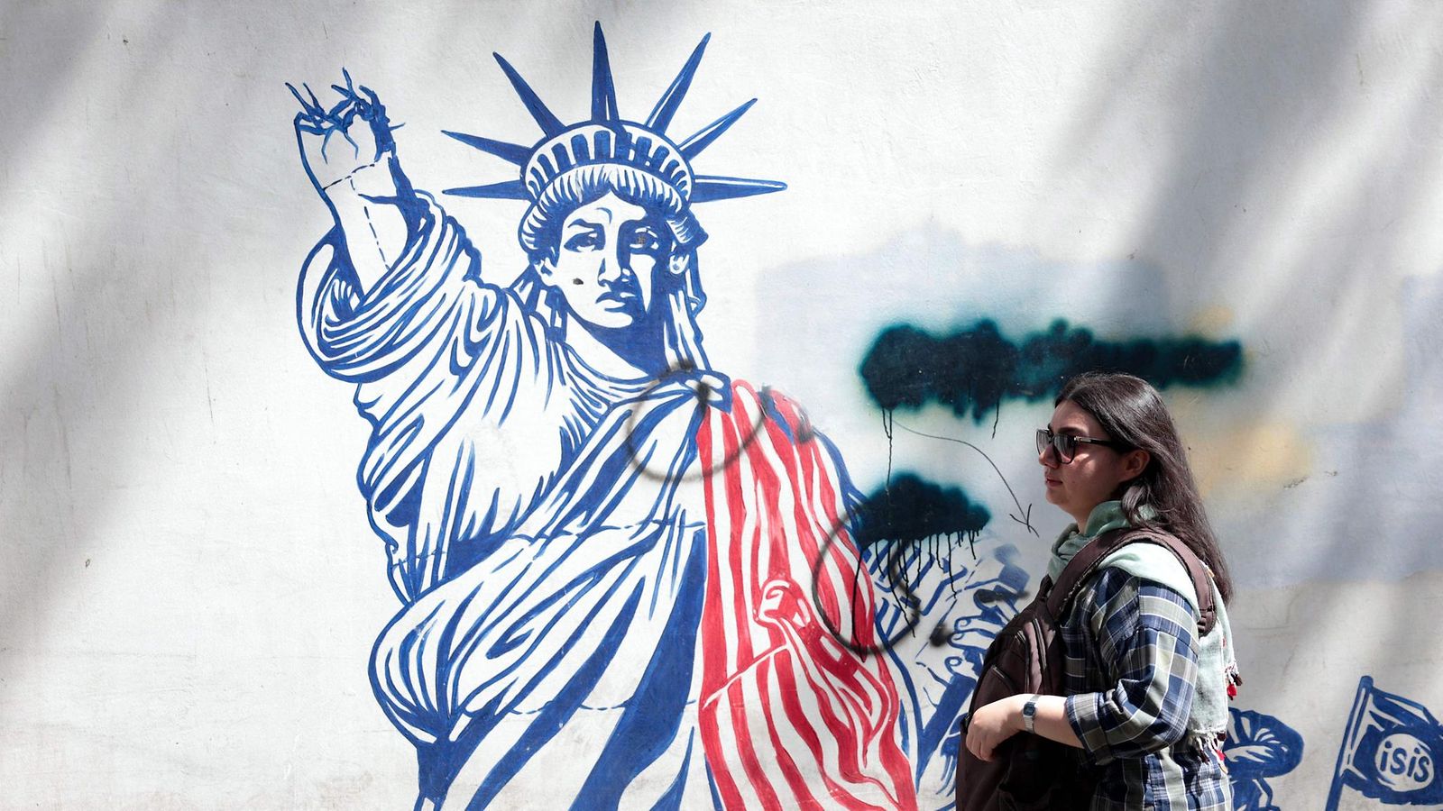 LK 11.5.2025 Nainen käveli Yhdysvaltain vastaisen seinämaalauksen vieressä lähellä USA:n entistä suurlähetystöä Teheranissa Iranissa 11. toukokuuta 2025.
