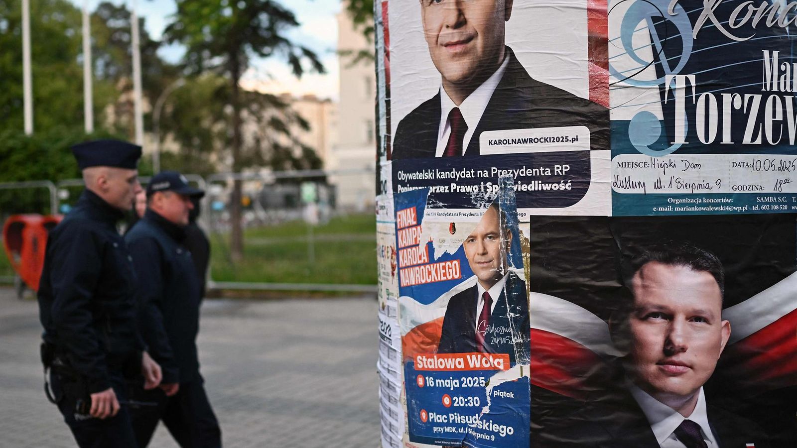 Poliisit kävelevät vaalimainosten ohi kadulla.