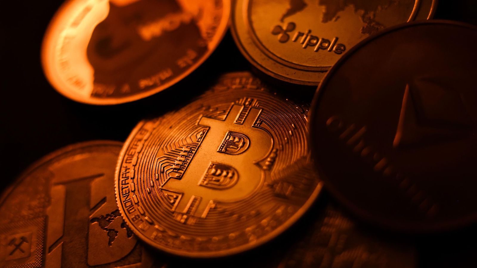 Erilaisia kryptovaluuttoja kolikoiksi kuvitettuina.