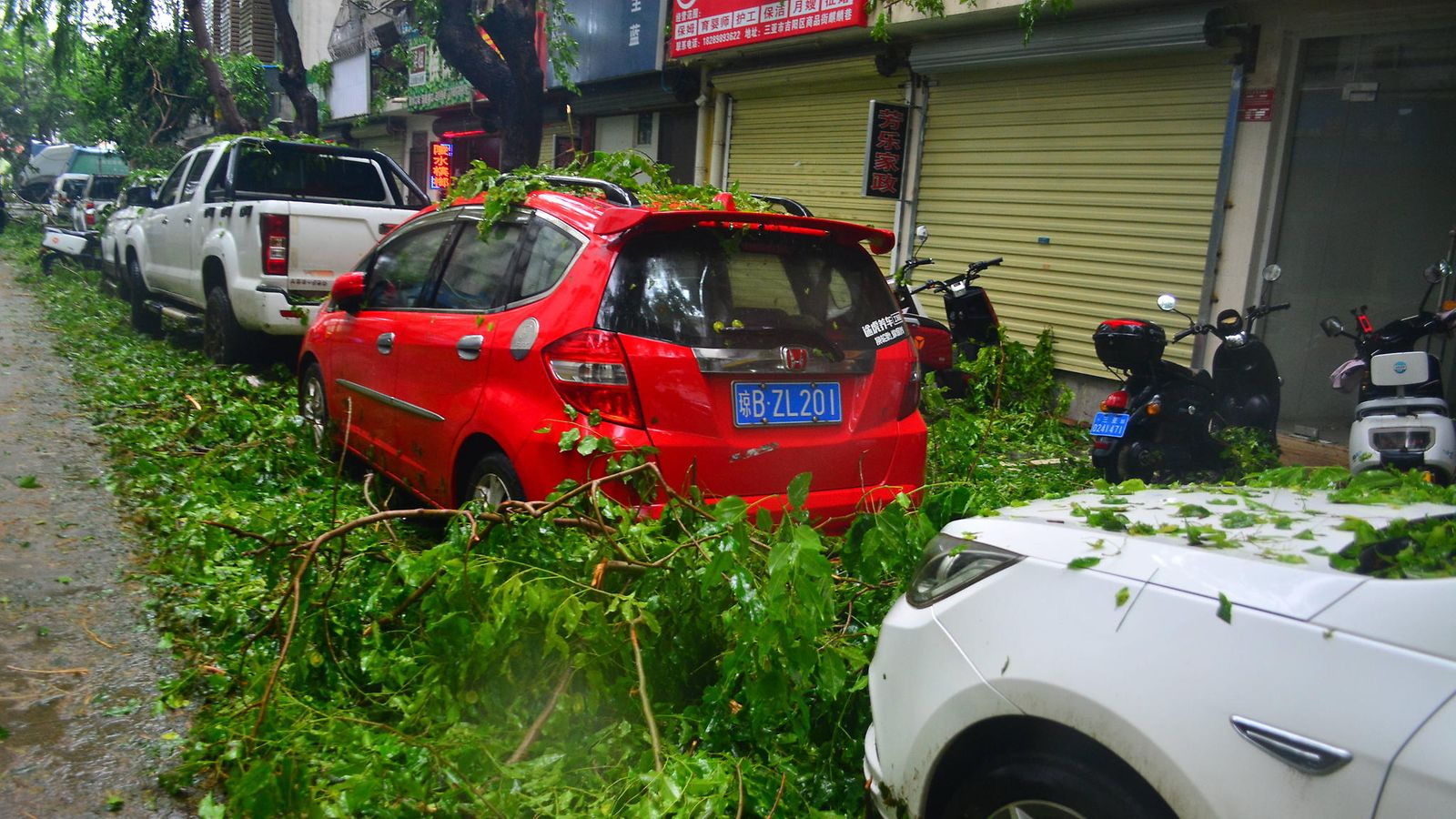 Tree branches toppled by strong winds fall on cars on June 13, 2025 in Sanya, Hainan Province of China. Tens of thousands of people have been evacuated to safety in Hainan as Typhoon Wutip, the first typhoon of the year, is approaching.