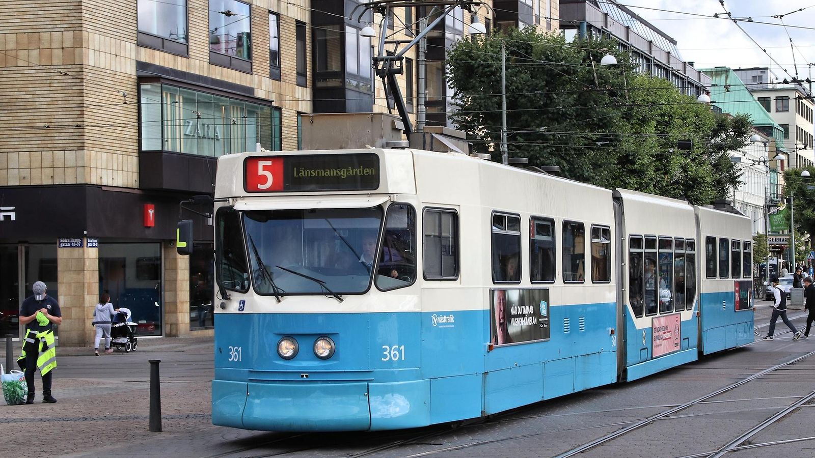 Sini-valkoinen raitiovaunu kulkee raiteillaan Göteborgissa.