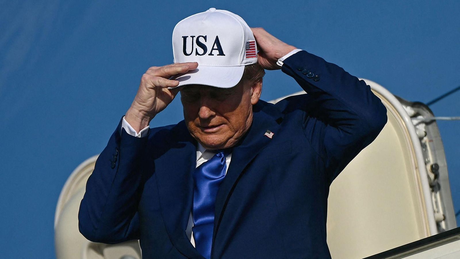 LK 24.6.2025 Yhdysvaltain presidentti Donald Trump sääti lippalakkiaan poistuessaan Air Force One -lentokoneesta Amsterdamin Schipholin lentokentälle osallistuakseen Naton huippukokoukseen Haagissa 24. kesäkuuta 2025.