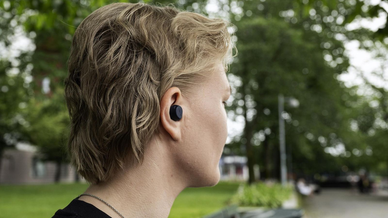 Nuori nainen bluetooth-nappikuulokkeet korvillaan Helsingissä 22. heinäkuuta 2025.