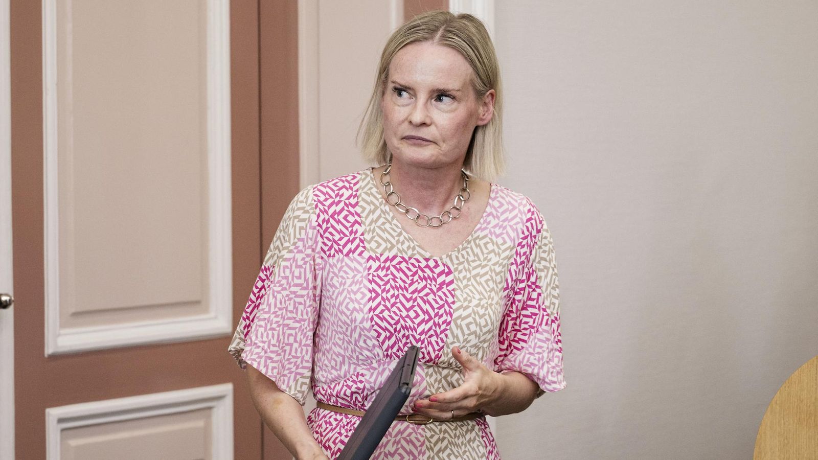 Riikka Purra lehdistötilaisuudessa kannettava tietokone käsissään.