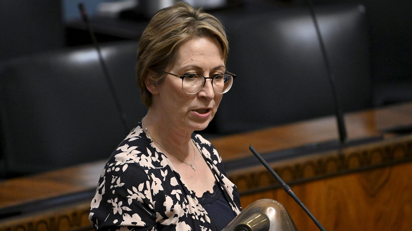 Sari Essayah puhuu mikrofoniin eduskunnan täysistuntosalissa.