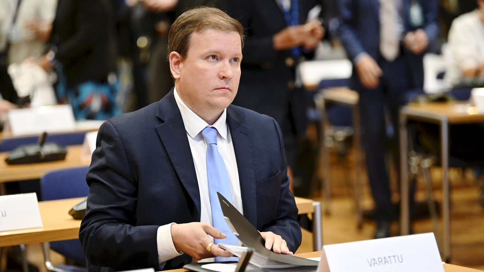 Ville Tavio istuu pöydän ääressä suurlähettiläskokouksessa.