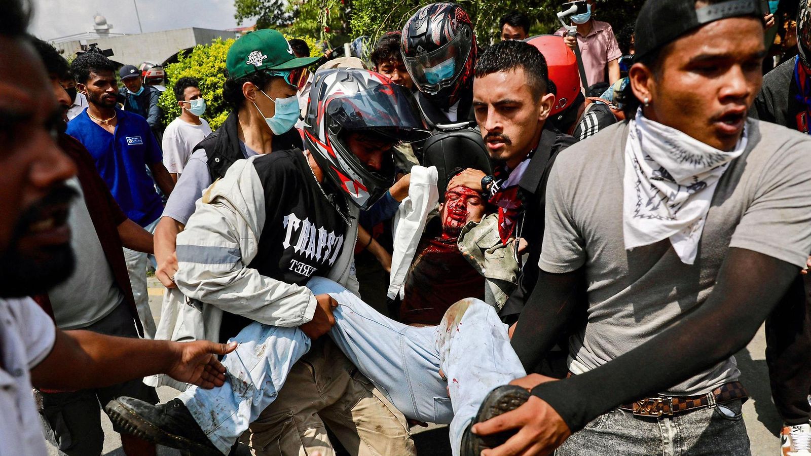 LK 8.9.2025 Mielenosoittajat kantoivat haavoittunutta Nepalin pääkaupungissa Kathmandussa.