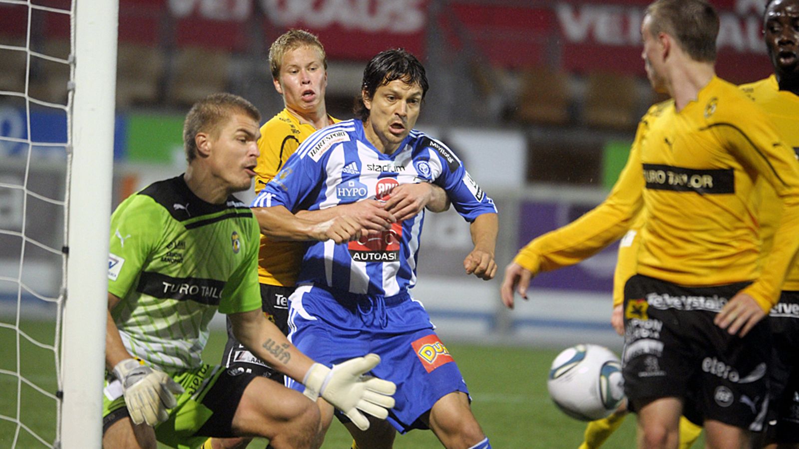 Jari Litmanen puolustuksen syliotteessa KuPS-maalilla.