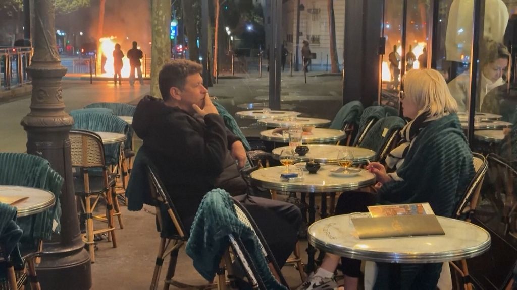 Kaksikko siemailee rauhassa juomiaan, vaikka Pariisi palaa – katso video