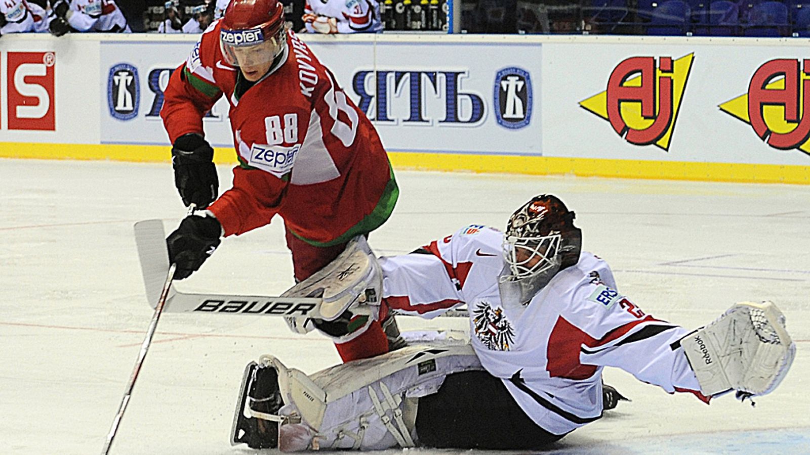 Valko-Venäjän Jevgeni Kovirshin yrittää ohittaa Itävallan maalivahtia Jürgen Penkeriä